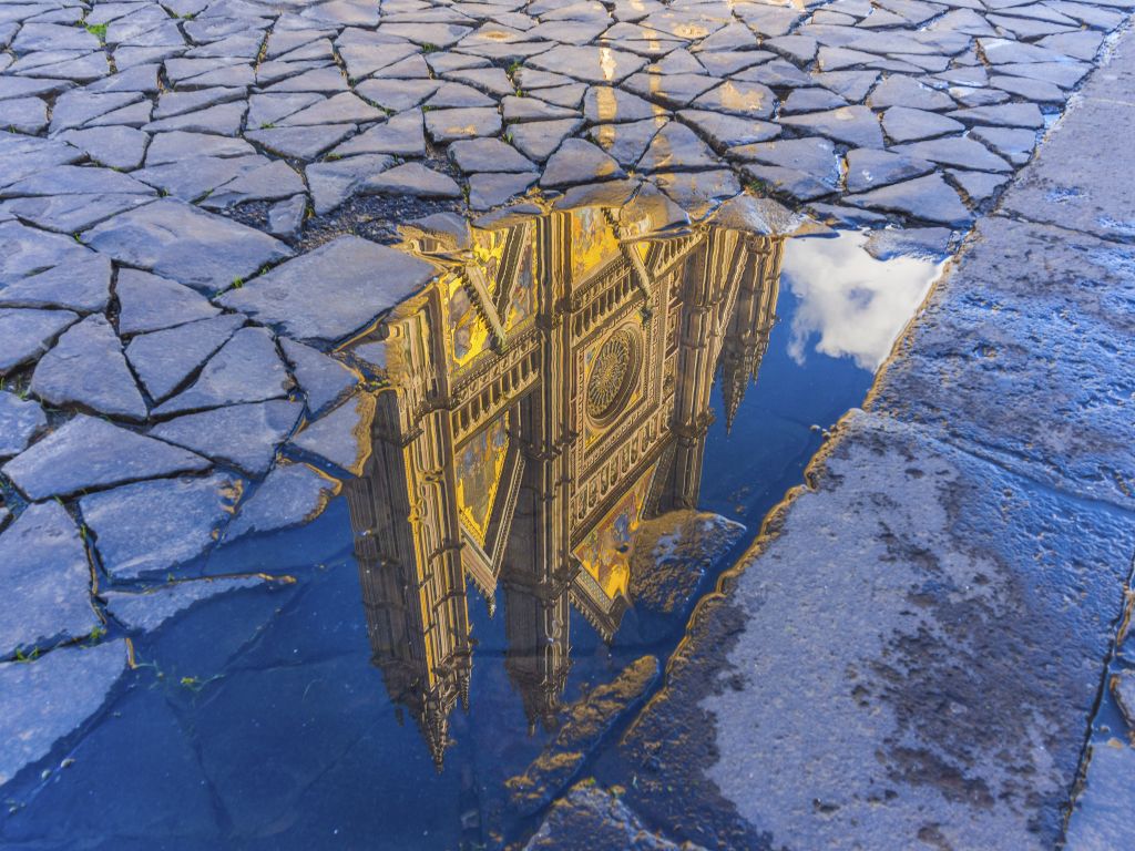 Reflection of the Orvieto cathedral in a water puddle, Umbria, Italy