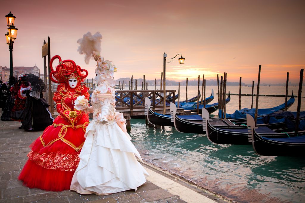 Sunrise in Venice Italy in front of Gondolas on the Grand Canal Beautiful costumed women